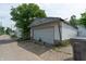 View of a detached one-car garage with an access alleyway, siding, and white door at 320 N Colorado Ave, Indianapolis, IN 46201