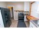 View of the kitchen with black refrigerator, black oven and view into other rooms at 320 N Colorado Ave, Indianapolis, IN 46201