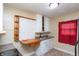 Compact kitchen featuring white cabinets, drop-in sink, and unique custom built-in table and shelving at 320 N Colorado Ave, Indianapolis, IN 46201