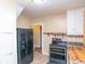Kitchen area showcasing black refrigerator, black oven, tan walls and view into other rooms at 320 N Colorado Ave, Indianapolis, IN 46201