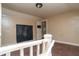 Upstairs hallway with drab walls, worn carpeting and an interior door at 320 N Colorado Ave, Indianapolis, IN 46201