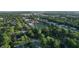An aerial view showcasing a charming neighborhood with mature trees, a football field, and well-maintained properties at 3253 W 34Th St, Indianapolis, IN 46222