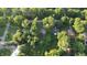 An aerial view of a home nestled among lush trees in a quiet neighborhood on a bright sunny day at 3253 W 34Th St, Indianapolis, IN 46222