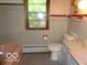 Retro bathroom with tiled walls and floors, including a pink bathtub and vintage fixtures at 3253 W 34Th St, Indianapolis, IN 46222