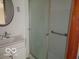 Bathroom featuring a shower with glass doors, a round mirror and a single sink vanity at 3253 W 34Th St, Indianapolis, IN 46222