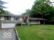 Charming single-story home with stone accents, lush lawn, and attached two-car garage at 3253 W 34Th St, Indianapolis, IN 46222