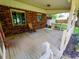 Relaxing covered back porch with brick walls and a cozy seating area offers a peaceful retreat at 336 N Windsong Ln, Greenwood, IN 46142