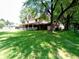 Expansive backyard featuring a covered porch, mature trees, and ample space for outdoor activities and relaxation at 336 N Windsong Ln, Greenwood, IN 46142