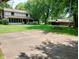A backyard with mature trees, a concrete pad, a large lawn, and a home with a covered porch, perfect for recreation and relaxation at 336 N Windsong Ln, Greenwood, IN 46142