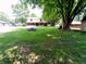 A backyard with mature trees, a large lawn, and a home with a covered porch, ideal for relaxation and outdoor activities at 336 N Windsong Ln, Greenwood, IN 46142
