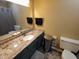 Bathroom features a granite countertop, a stainless steel trash can, and dark gray tiled flooring at 336 N Windsong Ln, Greenwood, IN 46142