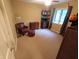 Bedroom with warm-colored walls, featuring a leather chair with ottoman, carpet, and a dark colored bookshelf at 336 N Windsong Ln, Greenwood, IN 46142