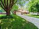 Inviting front exterior with lush lawn, mature trees, and a spacious driveway leading to the attached garage at 336 N Windsong Ln, Greenwood, IN 46142