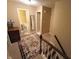 Upstairs hallway with decorative rug, wood banister, neutral walls, and a partial view of a bathroom at 336 N Windsong Ln, Greenwood, IN 46142