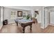 Spacious game room showcasing a pool table, wood floors, natural light, and seamless flow into adjacent rooms at 3546 Brampton Ln, Westfield, IN 46074
