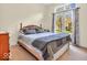 Cozy bedroom featuring a comfortable bed, a dresser, and large windows with decorative curtains at 3559 Towne Dr, Carmel, IN 46032