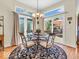 Bright dining area with large windows, stylish chandelier, and access to the outdoor deck at 3559 Towne Dr, Carmel, IN 46032