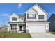 Charming two-story home featuring a two-car garage and a beautifully maintained lawn at 379 Antioch St, Greenfield, IN 46140