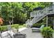 Backyard patio featuring a lounge chair, outdoor seating, well-manicured greenery and stairs leading to upper deck at 380 Raintree Dr, Zionsville, IN 46077