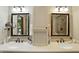 Bright bathroom with dual sinks, granite counters, decorative mirrors, and updated fixtures at 380 Raintree Dr, Zionsville, IN 46077