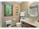 Neutral bathroom with an octagon mirror, floral prints, and a large window with green view at 380 Raintree Dr, Zionsville, IN 46077