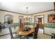 Elegant dining room with floral wallpaper, chandelier, and views into the living room at 380 Raintree Dr, Zionsville, IN 46077