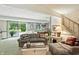 Cozy living room with stone fireplace, comfortable seating, pool table, and sliding glass doors to the patio at 380 Raintree Dr, Zionsville, IN 46077
