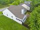 Aerial view of the backyard featuring a deck, green lawn, and mature trees at 3843 Grove Tree Ln, Indianapolis, IN 46203