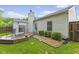 Backyard featuring a wooden deck, landscaped garden, and well-maintained lawn at 3843 Grove Tree Ln, Indianapolis, IN 46203