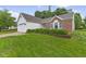 Beautifully landscaped front yard with lush green grass and manicured shrubbery at 3843 Grove Tree Ln, Indianapolis, IN 46203