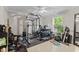Home gym featuring weightlifting rack, dumbbells, kettlebells, mirrors, and natural light at 3843 Grove Tree Ln, Indianapolis, IN 46203