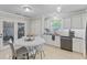 Eat-in kitchen features stainless steel appliances, bright lighting, and access to back patio at 3843 Grove Tree Ln, Indianapolis, IN 46203