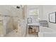 This bathroom boasts a tile shower with mosaic accents, a window for light and vanity area at 3843 Grove Tree Ln, Indianapolis, IN 46203