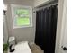 This bathroom features a window, black shower curtain, and modern fixtures at 3906 N Lanewood Dr, Muncie, IN 47304