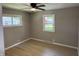 This bedroom features a ceiling fan, hard wood floors, and bright windows at 3906 N Lanewood Dr, Muncie, IN 47304