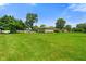 A well-maintained backyard with mature trees, a detached garage, and lush green grass at 45 Kirk E Dr, Indianapolis, IN 46234