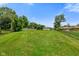 Large grassy backyard featuring mature trees, a detached garage, and chain link fencing at 45 Kirk E Dr, Indianapolis, IN 46234