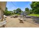 A backyard patio with comfortable seating, a firepit, and a detached two-car garage and mature trees at 45 Kirk E Dr, Indianapolis, IN 46234