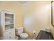 Bathroom with yellow paint, a cabinet, a tissue holder, and a toilet at 45 Kirk E Dr, Indianapolis, IN 46234