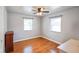 Well-lit bedroom boasts hardwood floors, a ceiling fan, and two windows, creating a bright and airy space at 45 Kirk E Dr, Indianapolis, IN 46234