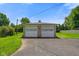 Detached two car garage featuring stone facade, asphalt driveway, and vintage lighting fixtures at 45 Kirk E Dr, Indianapolis, IN 46234
