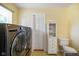 Laundry room with large washer and dryer set, as well as a utility closet and yellow paint at 45 Kirk E Dr, Indianapolis, IN 46234