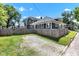Backyard with a privacy fence, gravel parking area, and a well-maintained lawn at 4721 Carrollton Ave, Indianapolis, IN 46205