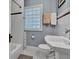 Charming bathroom featuring hexagon tile floor, a pedestal sink and glass block window at 4721 Carrollton Ave, Indianapolis, IN 46205