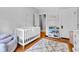 Bedroom with white crib, grey patterned rug, and a book shelf at 4721 Carrollton Ave, Indianapolis, IN 46205