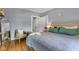 Cozy bedroom featuring hardwood floors, neutral paint, chair, and a mirror at 4721 Carrollton Ave, Indianapolis, IN 46205