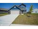 Charming two-story home with blue siding, brick accents, a spacious driveway, and manicured lawn at 507 Redvine Dr, Sheridan, IN 46069