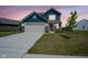 Charming two-story home with blue siding, brick accents, spacious driveway, and manicured lawn at dusk at 507 Redvine Dr, Sheridan, IN 46069