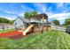 Backyard with a wooden deck, a slide, a pergola, and a well-maintained lawn at 5821 Pemberly Dr, Indianapolis, IN 46221