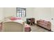 Comfortable bedroom setup with a bed, desk, and a storage bench by the window at 5821 Pemberly Dr, Indianapolis, IN 46221